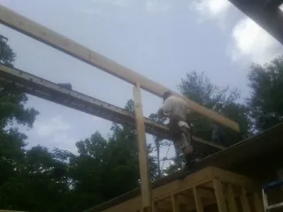 Carpenter setting a ridge beam over a new addition frame — Ice Dam Removal by Roofing Brothers in Glenmoore