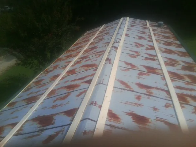 Rusted metal roof panels with new wood purlins before replacement — Storm Damage Roof Repair in Glenmoore by Roofing Brothers