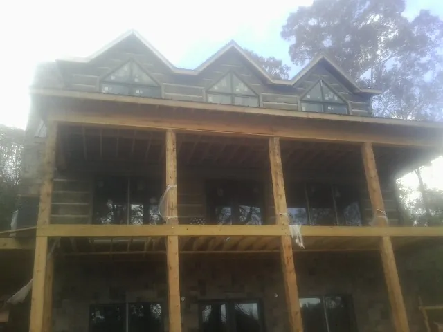 Dormers and porch framing on a large log home under construction — Roof Coating work by our crew in Glenmoore