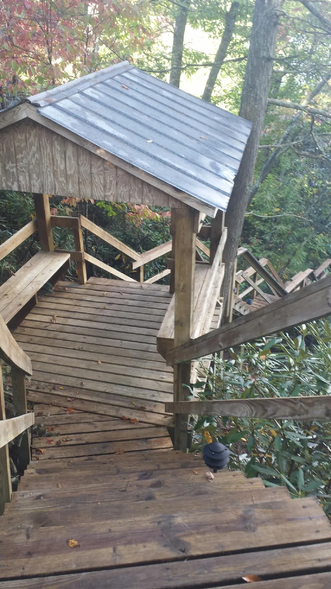 Metal roofed shelter over wooden steps on a wooded walkway — Skylight Repair & Installation work by our crew in Glenmoore