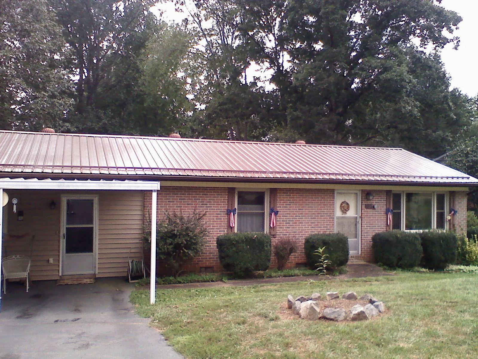 Bronze metal roof and carport on a brick ranch home — Roof Repair work by our crew in Glenmoore